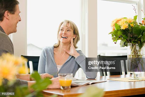 happy couple laughing and sitting in dining table - white rock bc stock pictures, royalty-free photos & images