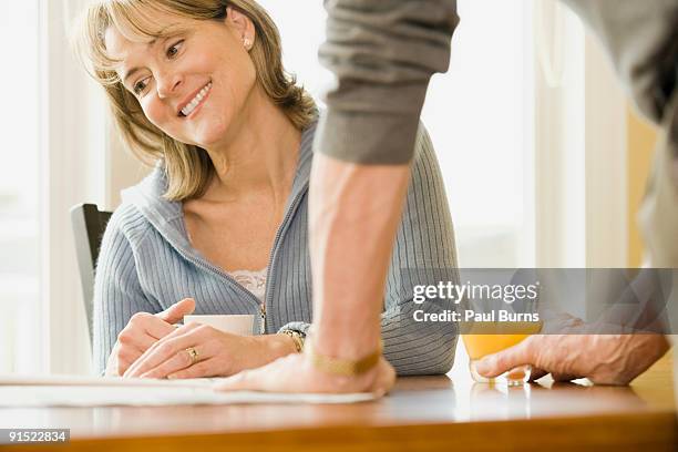 wife looking at statements and smiling - white rock bc stock pictures, royalty-free photos & images