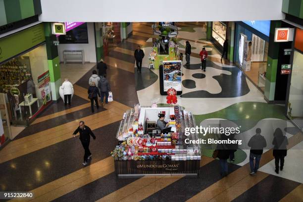 Vendor waits for customers at her candy kiosk in a shopping arcade at the Dolce Vita Tejo shopping mall, operated by AXA Real Estate Investment...