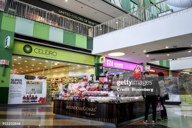 Visitors browse confectionary on display at a candy kiosk in a shopping arcade at the Dolce Vita Tejo shopping mall, operated by AXA Real Estate...