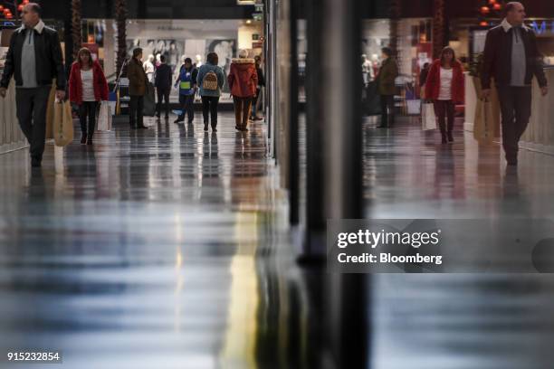 Customers walk through a shopping arcade at the Dolce Vita Tejo shopping mall, operated by AXA Real Estate Investment Managers SGR SpA, in Lisbon,...