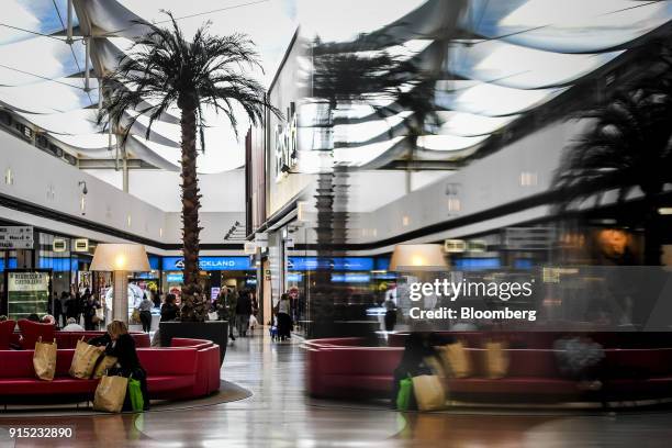 Customer arranges her shopping bags after visiting the Primark Stores Ltd. Shop at the Dolce Vita Tejo shopping mall, operated by AXA Real Estate...