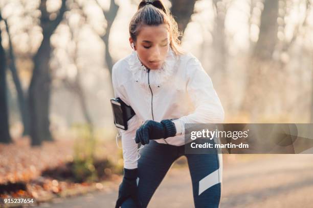 sportvrouw controleren van pulse - fitness armband stockfoto's en -beelden