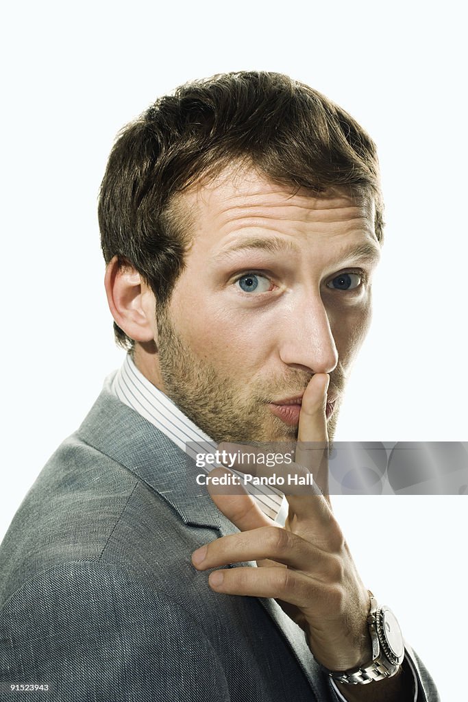 Businessman with finger on lips, close-up