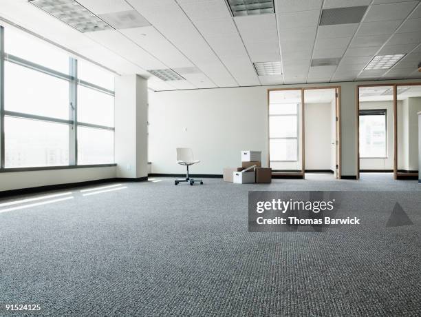 empty office with boxes and one chair - office chair stock pictures, royalty-free photos & images