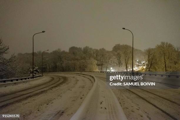 The snow-covered N118 main road is deserted near Velizy-Villacoublay overnight on February 7 after its closure following heavy overnight snowfall in...