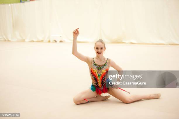 rhythmic gymnastics athlete sitting on floor after landing - super excited suit stock pictures, royalty-free photos & images