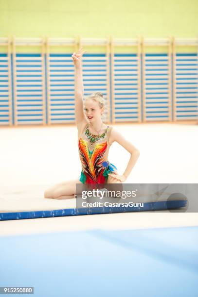 rhythmic gymnastics athlete sitting on floor after landing - super excited suit stock pictures, royalty-free photos & images