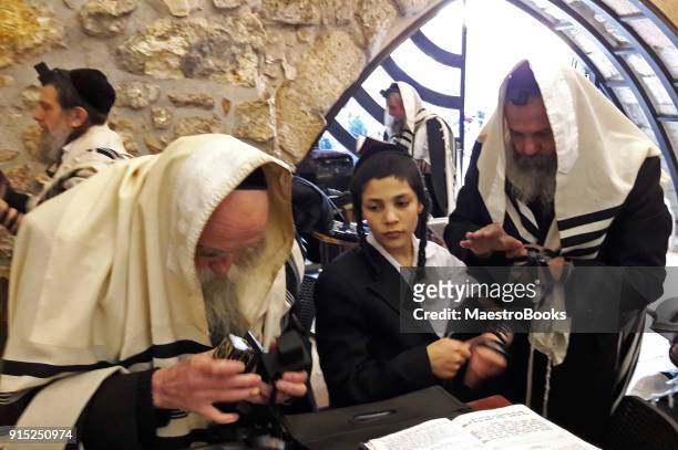 young jewish man learns to put tefilim in the wailing wall - jerusalem sunrise stock pictures, royalty-free photos & images