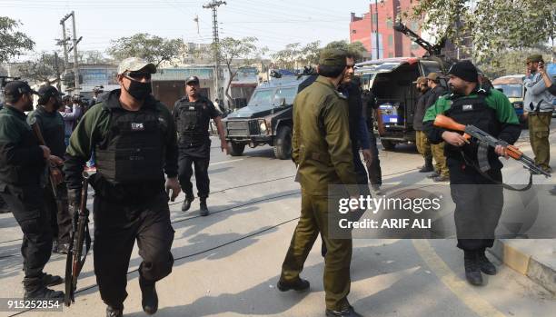 Pakistani police commandos escort a police van carrying a suspect accused of raping and murdering a young girl, as they arrive at an anti-terrorist...
