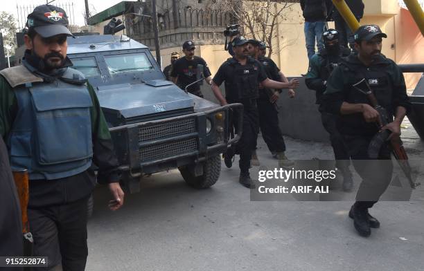 Pakistani police commandos escort a police van carrying a suspect accused of raping and murdering a young girl, as they arrive at an anti-terrorist...