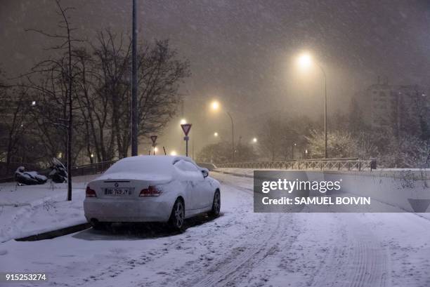 Snow-covered car was parked on the road, in Velizy-Villacoublay, southwestern suburbs of Paris, early February 7 after heavy overnight snowfall in...