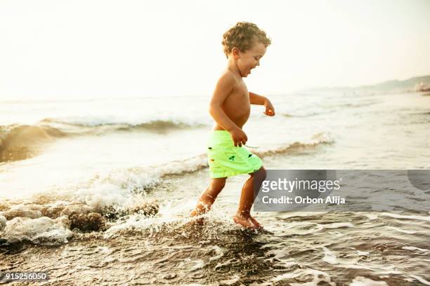 jongen op het strand - alleen één jongen stockfoto's en -beelden