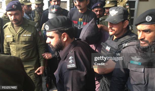 Pakistani police and commandos escort a suspect who is accused of raping and murdering a young girl, as they leave an anti-terrorist court in Lahore...