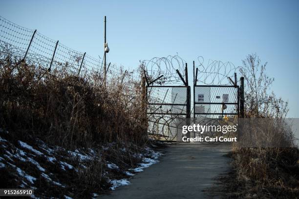 Barbed wire fence runs alongside the Han River near the Demilitarized Zone between South and North Korea on February 7, 2018 near Panmunjom, South...