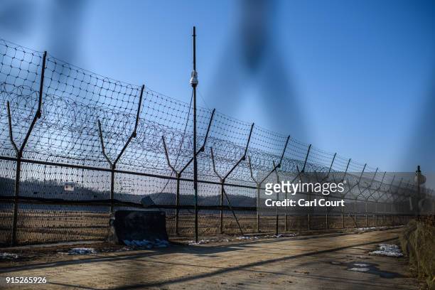 Barbed wire fence runs alongside the Han River near the Demilitarized Zone between South and North Korea on February 7, 2018 near Panmunjom, South...