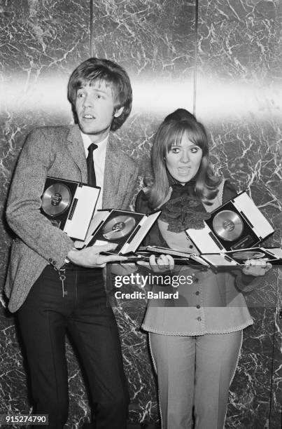British singer-songwriter Lulu with British-American singer-songwriter, composer and record producer Scott Walker hold the awards they have received...