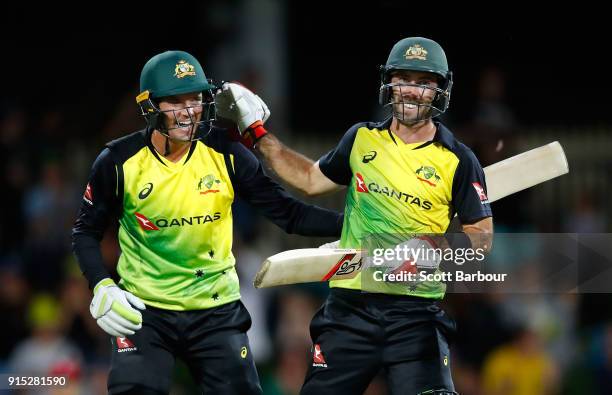 Glenn Maxwell of Australia celebrates his century with Alex Carey after hitting a six from the last ball during the Twenty20 International match...