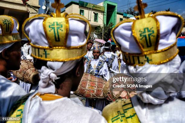 Christians in the traditional white shrouds play the drums during the procession through the streets of Gondar. The annual Timkat festival, an...