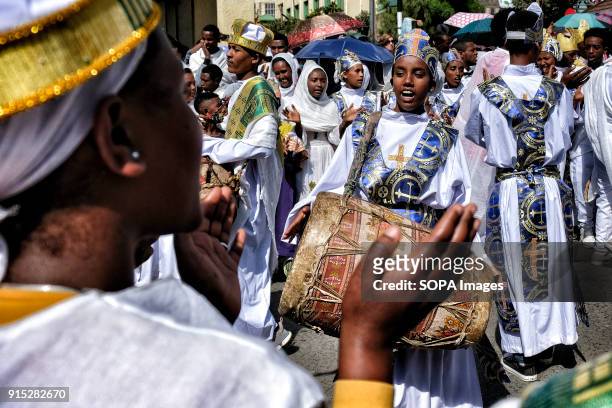 Christians in the traditional white shrouds play the drums during the procession through the streets of Gondar. The annual Timkat festival, an...