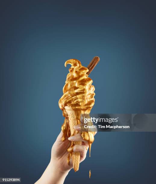 hand holding a gold ice cream - melted chocolate stock pictures, royalty-free photos & images
