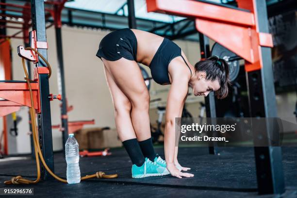 woman is stretching her long legs on the fitness and circuit training - beautiful long legs imagens e fotografias de stock