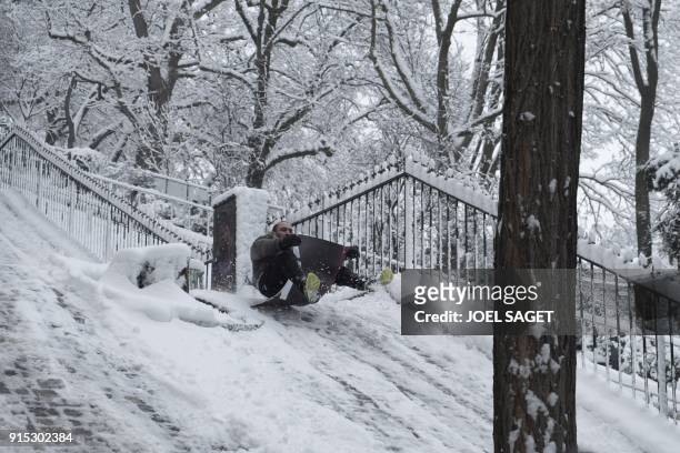 Man sleds down an inclined plane on February 7, 2018 following heavy snowfall in Paris. - Exceptionally heavy snowfall brought public transport in...