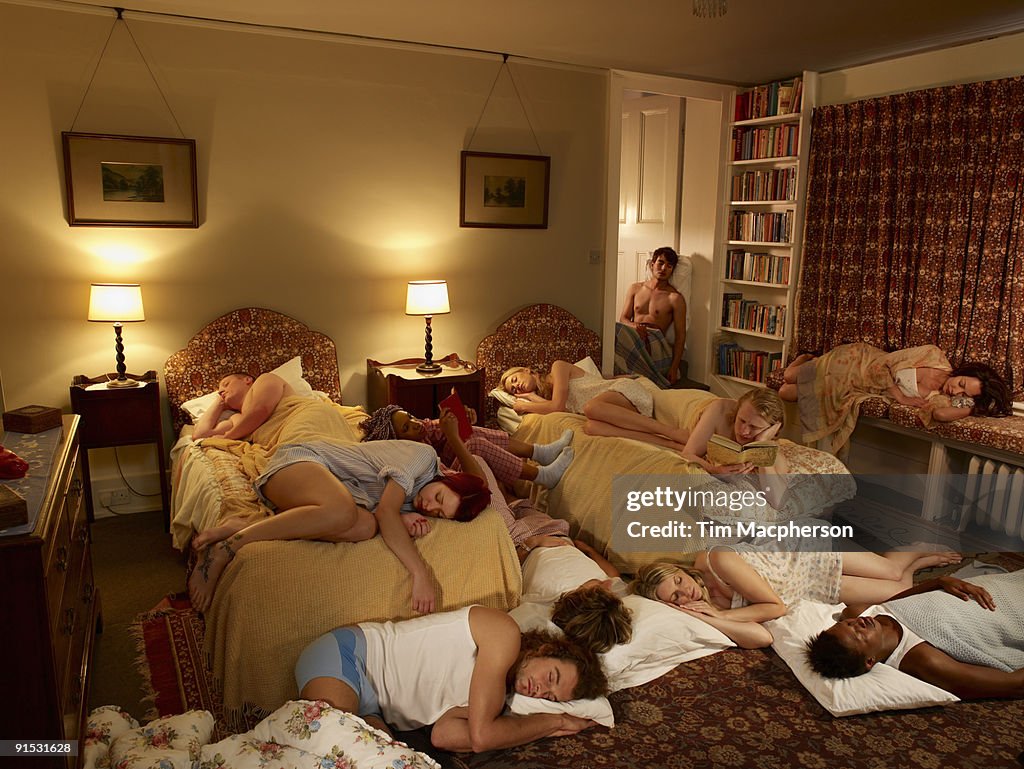 Group of people asleep in a bedroom