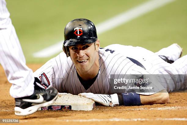 Joe Mauer of the Minnesota Twins dives back toward first after a single during the American League Tiebreaker game against the Detroit Tigers on...