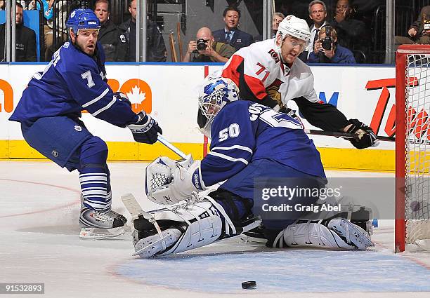 Ian White of the Toronto Maple Leafs checks Nick Foligno the Ottawa Senators as goalie Jonas Gustavsson during game action October 6, 2009 at the Air...