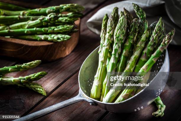 fresh asparagus in an old metal colander - asparagus stock pictures, royalty-free photos & images