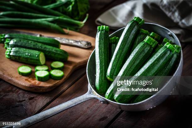 zucchini in eine alte metall sieb - courgette stock-fotos und bilder