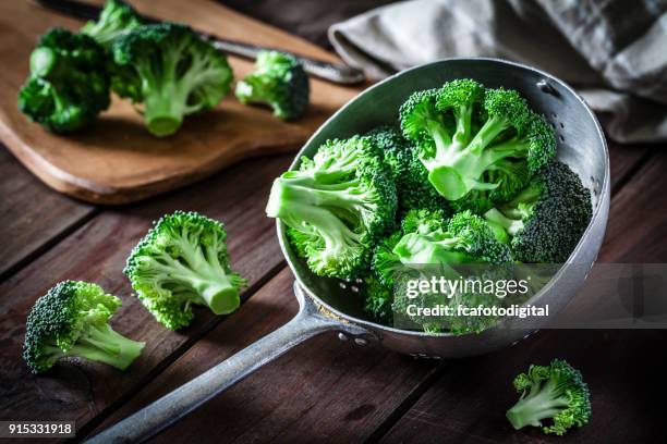 broccoli in an old metal colander - broccoli stock pictures, royalty-free photos & images