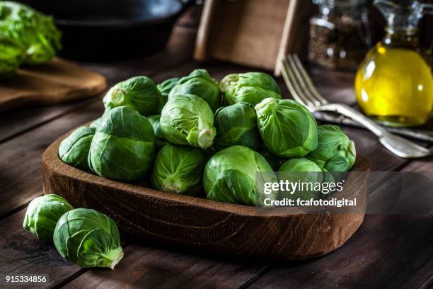 fresh organic brussels sprouts shot on rustic wooden table - brussel sprout stock pictures, royalty-free photos & images