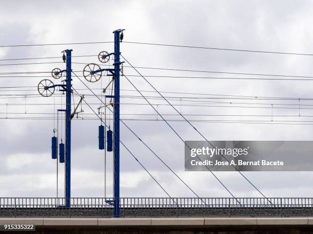 railroad track of the high-speed train ave on a bridge, with his electrical towers and	catenary. valencia, spain - metra train stock pictures, royalty-free photos & images