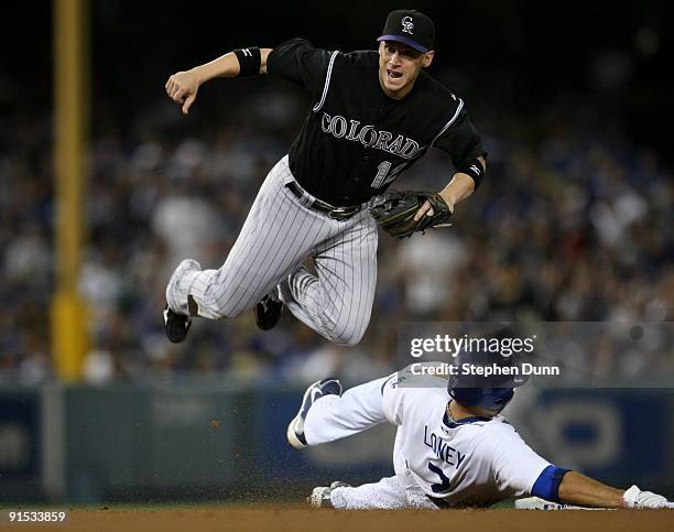 Shortstop Clint Barmes of the Colorado Rockies watches his throw to first to turn the double play as he jumps over James Loney of the Los Angeles...