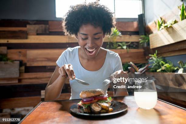 schöne afrikanische amerikanische frau essen einen leckeren bagel mit gemüse - geniessen teller essen stock-fotos und bilder