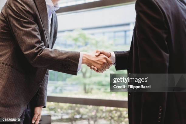 japanese businessmen shaking hands - diplomati stock pictures, royalty-free photos & images