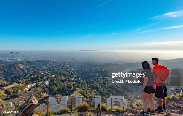 hollywood sign and hikers with los angeles in the background - hollywood sign stock pictures, royalty-free photos & images