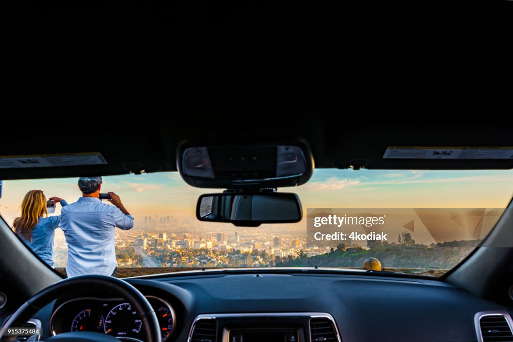 People taking photo of Los Angeles after sunset from Hollywood Bowl.