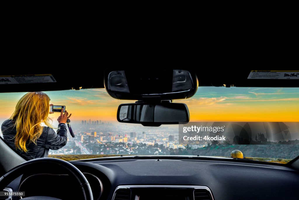 People taking photo of Los Angeles after sunset from Hollywood Bowl.