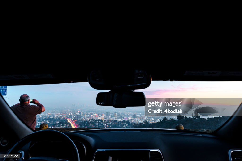 People taking photo of Los Angeles after sunset from Hollywood Bowl.