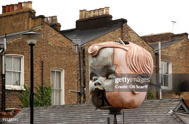 Artist Sam Haggarty's child's head artwork is seen against a backdrop of terraced houses in the 'One Foot in the Grove' exhibition of street art by...