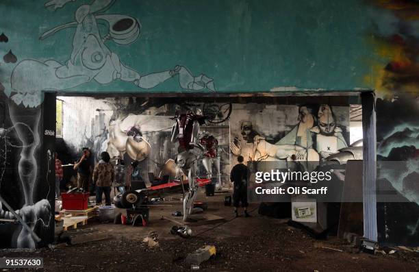 Artists put the finishing touches to the 'One Foot in the Grove' exhibition of street art by 'Mutate Britain' under the Westway flyover on October 6,...