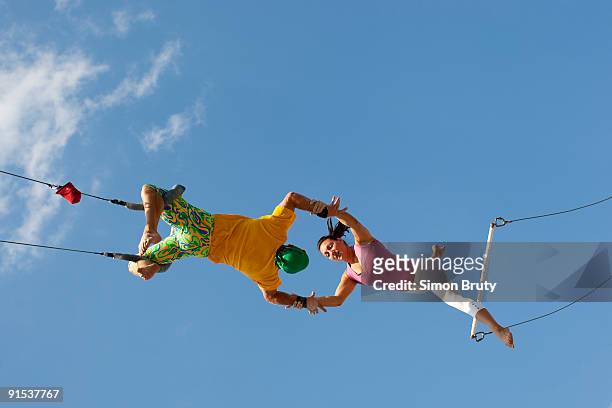 exercise on trapeze swings are popular - trapeze artist stock pictures, royalty-free photos & images
