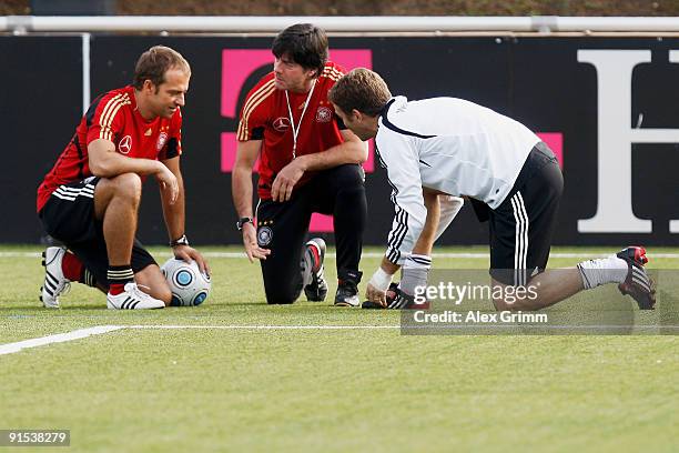 Assistant coach Hansi Flick, head coach Joachim Loew and team manager Oliver Bierhoff check the artificial turf during a training session of the...