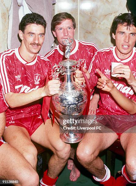 Liverpool players Ian Rush, Ronnie Whelan and captain Alan Hansen celebrate winning the league title with the trophy in the dressing room after the...