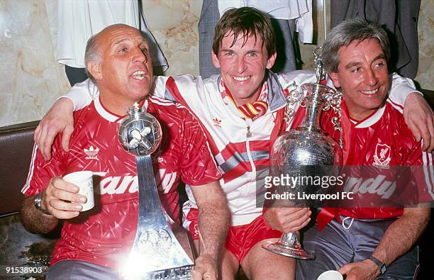 Liverpool manager Kenny Dalglish with coach Ronnie Moran and assistant manager Roy Evans celebrate winning the league title with the trophy in the...