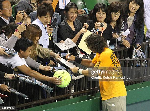 Juan Monaco of Argentina signs autographs for his fans after playing his match against Guillermo Garcia-Lopez of Spain during day three of the...