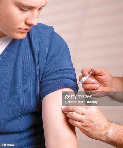 teenager receiving flu vaccination. - man flu foto e immagini stock
